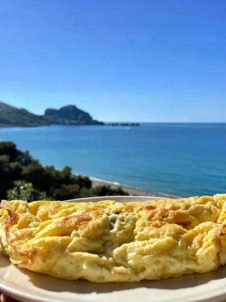 Omelette di albumi soffice e dorata con vista mare a Cefalù
