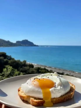 Uovo in camicia su toast croccante con vista sul mare di Cefalù
