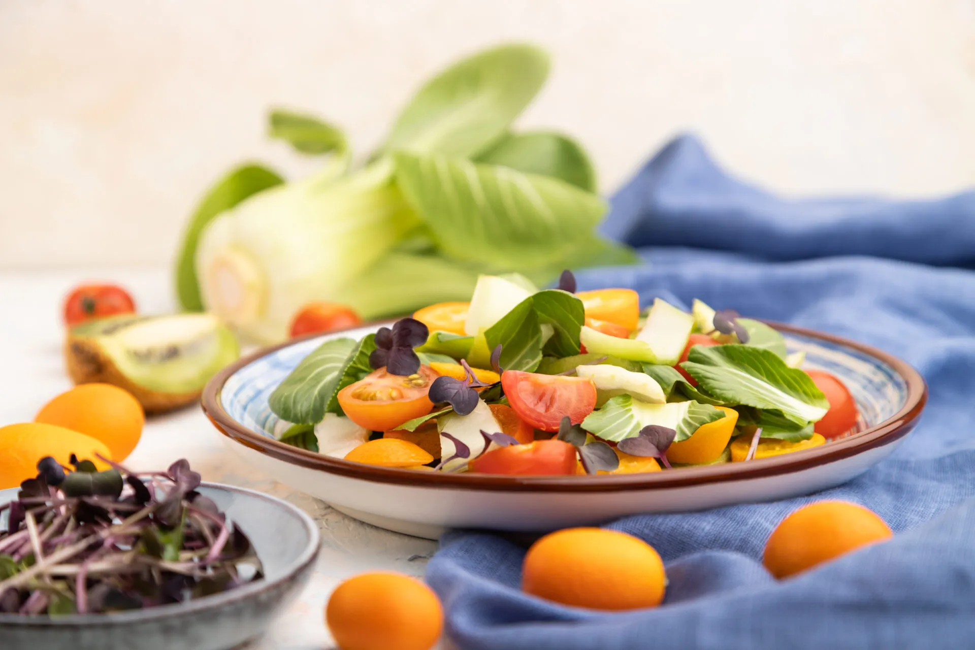 Insalata light estiva con finocchi, pomodorini colorati, agrumi e foglie verdi servita in un piatto su tavola chiara.
