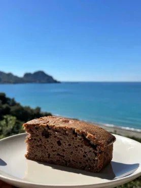 Fetta di banana bread senza uova con cioccolato e noci vista mare a Cefalù