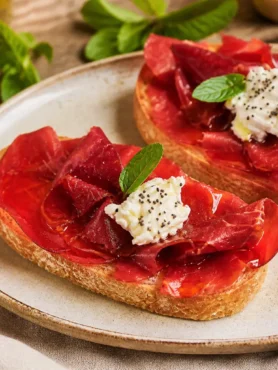 Bruschette fit con bresaola, ricotta light, semi di papavero e menta fresca