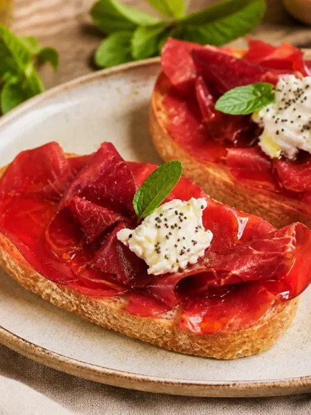 Bruschette fit con bresaola, ricotta light, semi di papavero e menta fresca