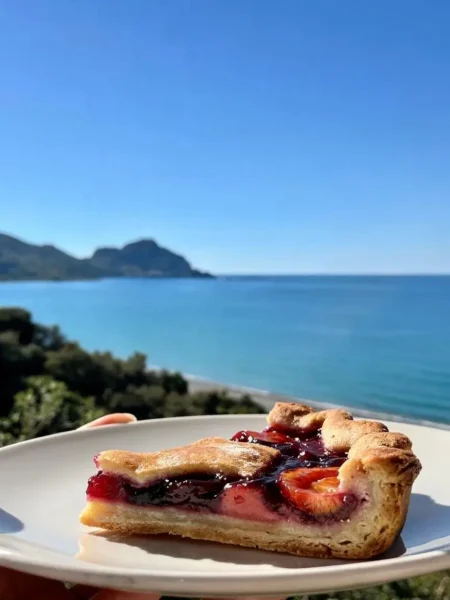 Fetta di crostata vegana integrale ai frutti rossi vista mare a Cefalù