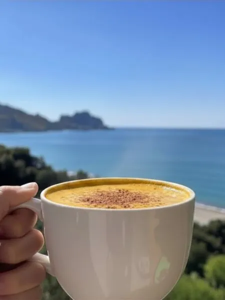 Latte speziato alla zucca light in tazza con vista mare a Cefalù