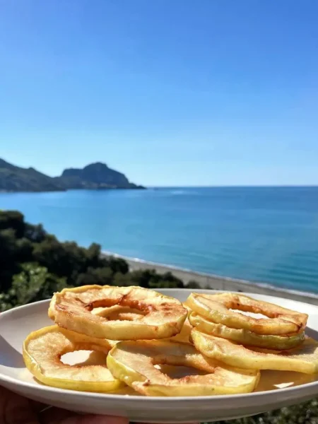 Frittelle di mele in padella light su piatto con vista mare a Cefalù