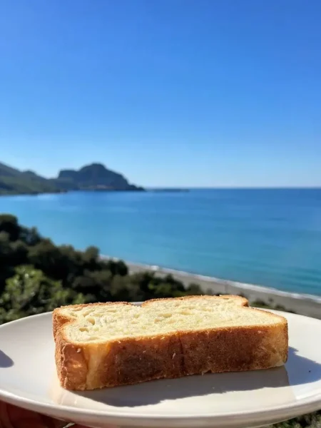 Fetta di pan brioche integrale su piatto con vista mare a Cefalù
