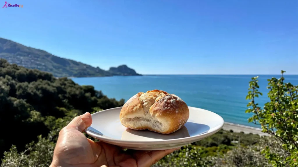 Panino senza olio su piatto bianco con vista mare a Cefalù