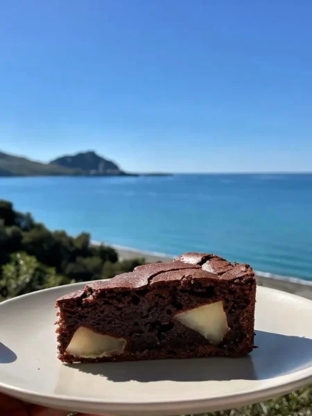 Fetta di plumcake pere e cacao light con vista mare a Cefalù