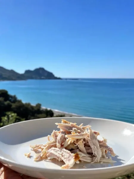 Pollo sfilacciato senza grassi in piatto bianco vista mare a Cefalù