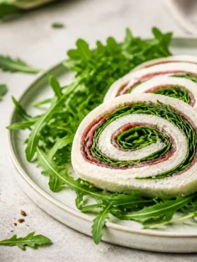 Girelle di pancarrè con bresaola, rucola e crema leggera su piatto