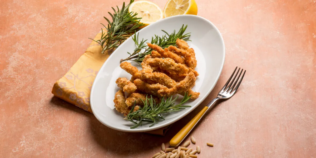 Panatura croccante al forno con bocconcini impanati dorati serviti con limone e rosmarino