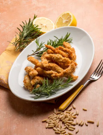 Panatura croccante al forno con bocconcini impanati dorati serviti con limone e rosmarino
