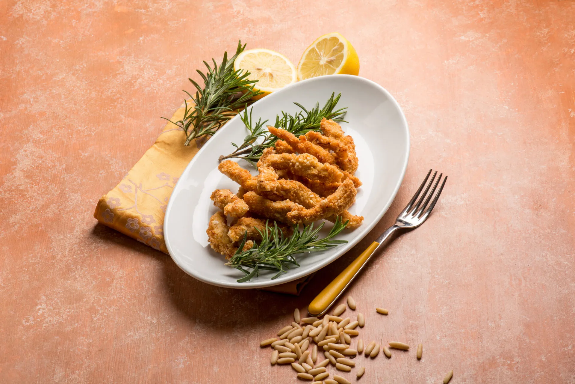 Panatura croccante al forno con bocconcini impanati dorati serviti con limone e rosmarino