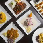 Tavola con diverse portate leggere e bilanciate per una cena con ospiti, tra primi piatti, secondi di pesce e contorni salutari.