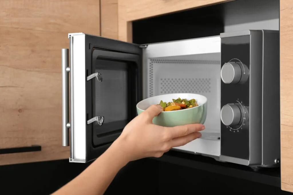 Forno a microonde moderno utilizzato per la cottura e il riscaldamento rapido di alimenti e verdure.