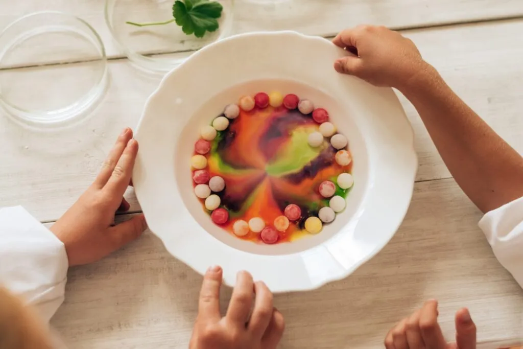 Piatto di cucina molecolare con sfere alimentari colorate e tecniche di sferificazione, esempio di gastronomia innovativa.