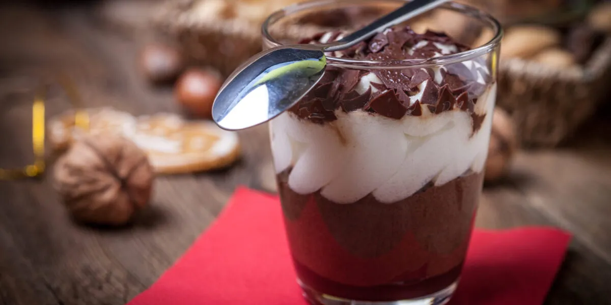 Mousse al cioccolato servita in bicchiere con crema soffice e scaglie di cioccolato, tra i dolci al cucchiaio più amati del 2026