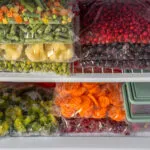 Sacchetti con verdure e frutta congelate ordinatamente sistemati nel freezer per una corretta conservazione degli alimenti.