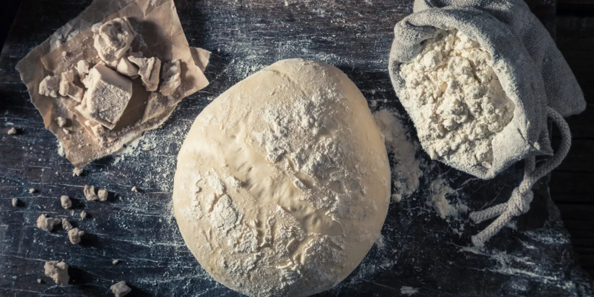 Impasto lievitato con lievito di birra fresco e farina, esempio di lievitazione naturale per pane, pizza e prodotti da forno.