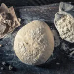 Impasto lievitato con lievito di birra fresco e farina, esempio di lievitazione naturale per pane, pizza e prodotti da forno.