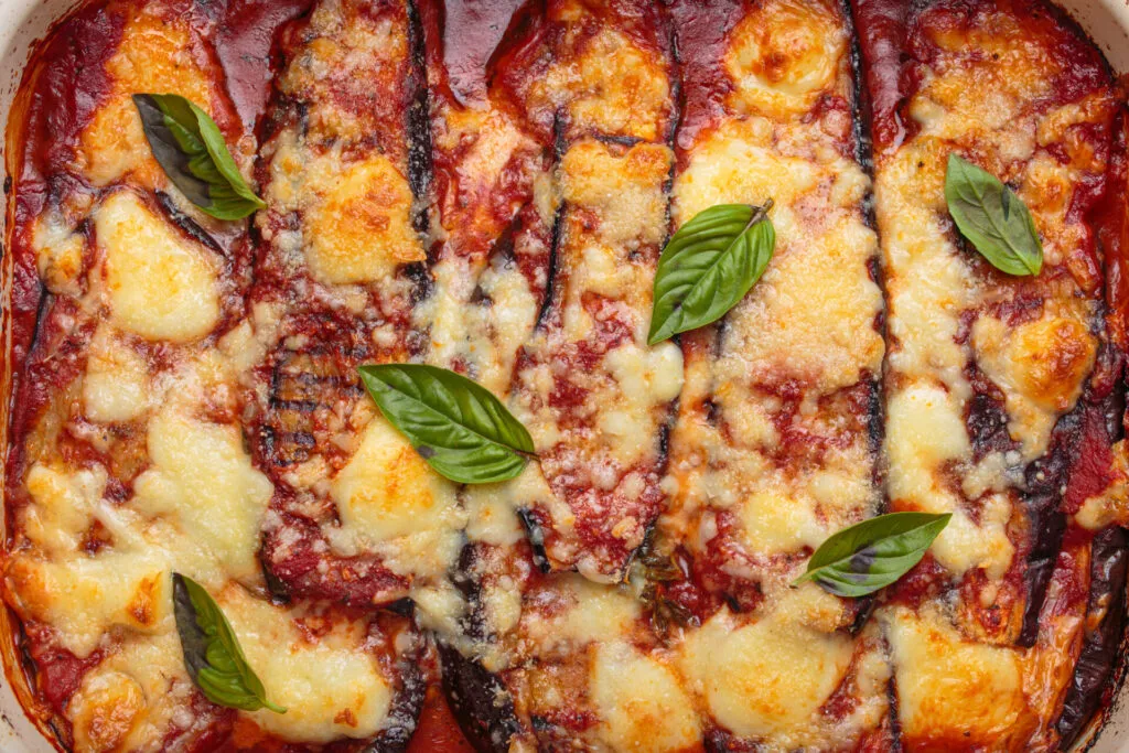 Parmigiana di melanzane light con pomodoro, mozzarella e basilico, versione leggera di un classico della cucina campana.