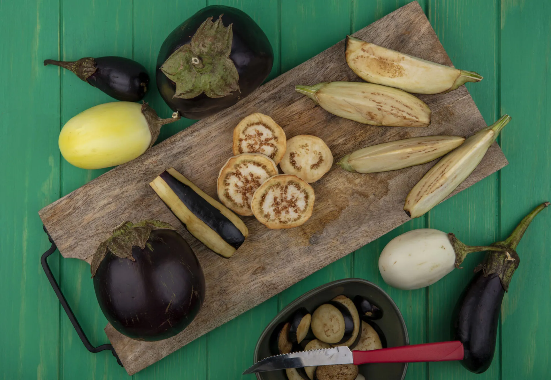 Melanzane fresche viola e bianche tagliate su tagliere in legno, ingrediente protagonista di ricette leggere con melanzane e piatti fit estivi.