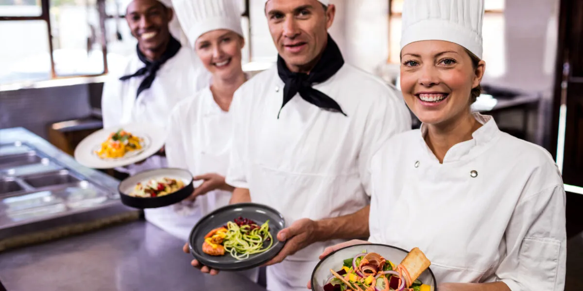 Chef e personale di cucina presentano piatti sani e colorati in un ristorante fit, con bowl ricche di verdure fresche e ingredienti equilibrati per un’alimentazione leggera e gustosa.