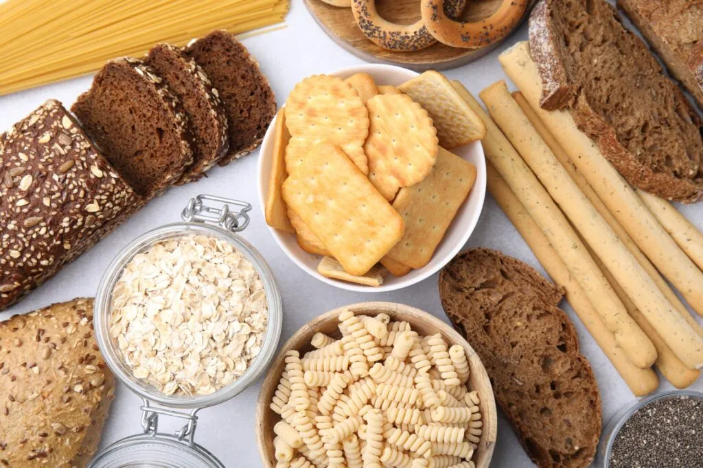 Alimenti ricchi di carboidrati come pane integrale, avena, pasta, cracker e grissini, fonti di energia da inserire in una dieta equilibrata.
