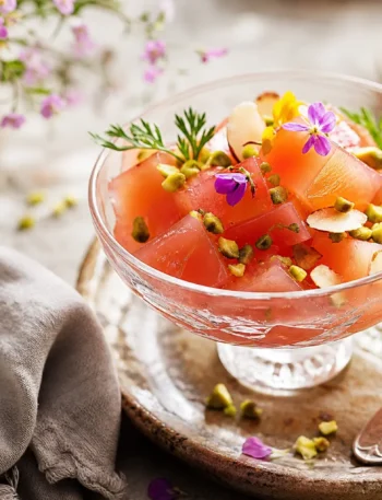 Gelo di cannella in coppa con pistacchi, mandorle e fiori eduli