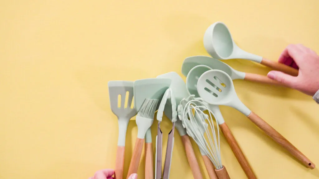 Mestoli e utensili da cucina in silicone con manici in legno, perfetti per pentole e padelle antiaderenti.