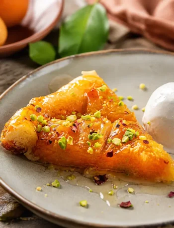 Fetta di torta rovesciata alle albicocche con yogurt greco e pistacchi