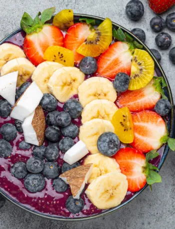 Acai bowl con frutta fresca, banana, fragole, mirtilli e cocco: colazione fit ricca di antiossidanti e fibre.