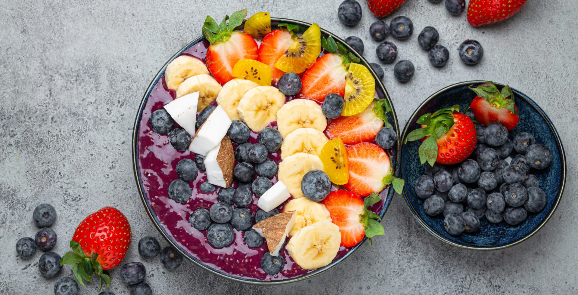 Acai bowl con frutta fresca, banana, fragole, mirtilli e cocco: colazione fit ricca di antiossidanti e fibre.