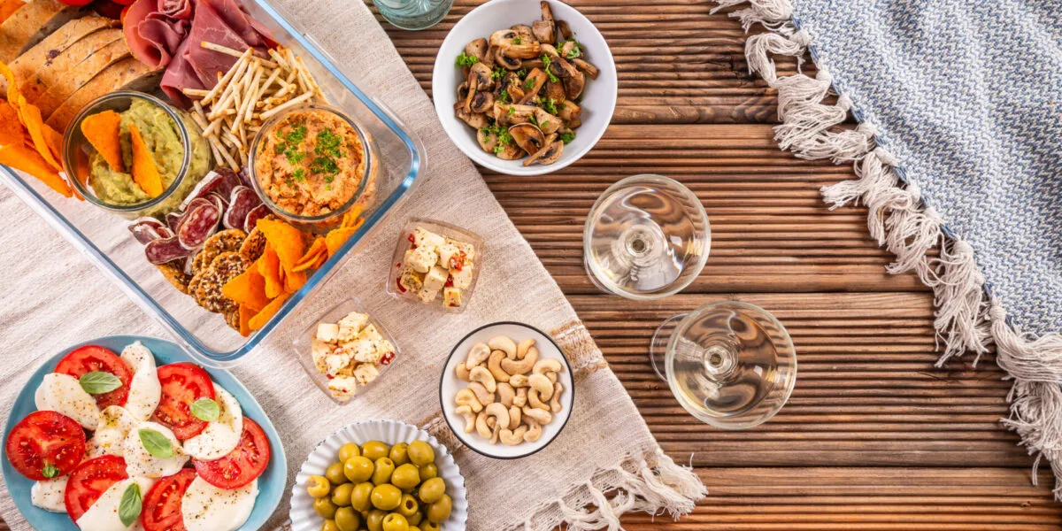 Aperitivo fit fatto in casa con stuzzichini leggeri, verdure, creme, crackers, formaggi, frutta secca e affettati.