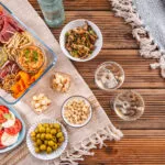 Aperitivo fit fatto in casa con stuzzichini leggeri, verdure, creme, crackers, formaggi, frutta secca e affettati.
