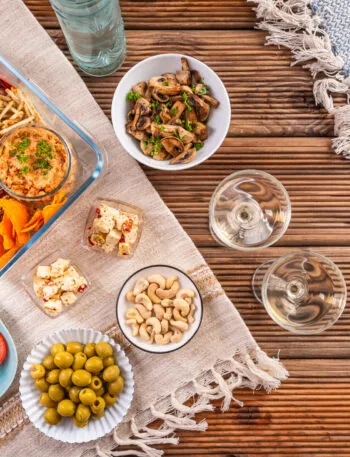 Aperitivo fit fatto in casa con stuzzichini leggeri, verdure, creme, crackers, formaggi, frutta secca e affettati.