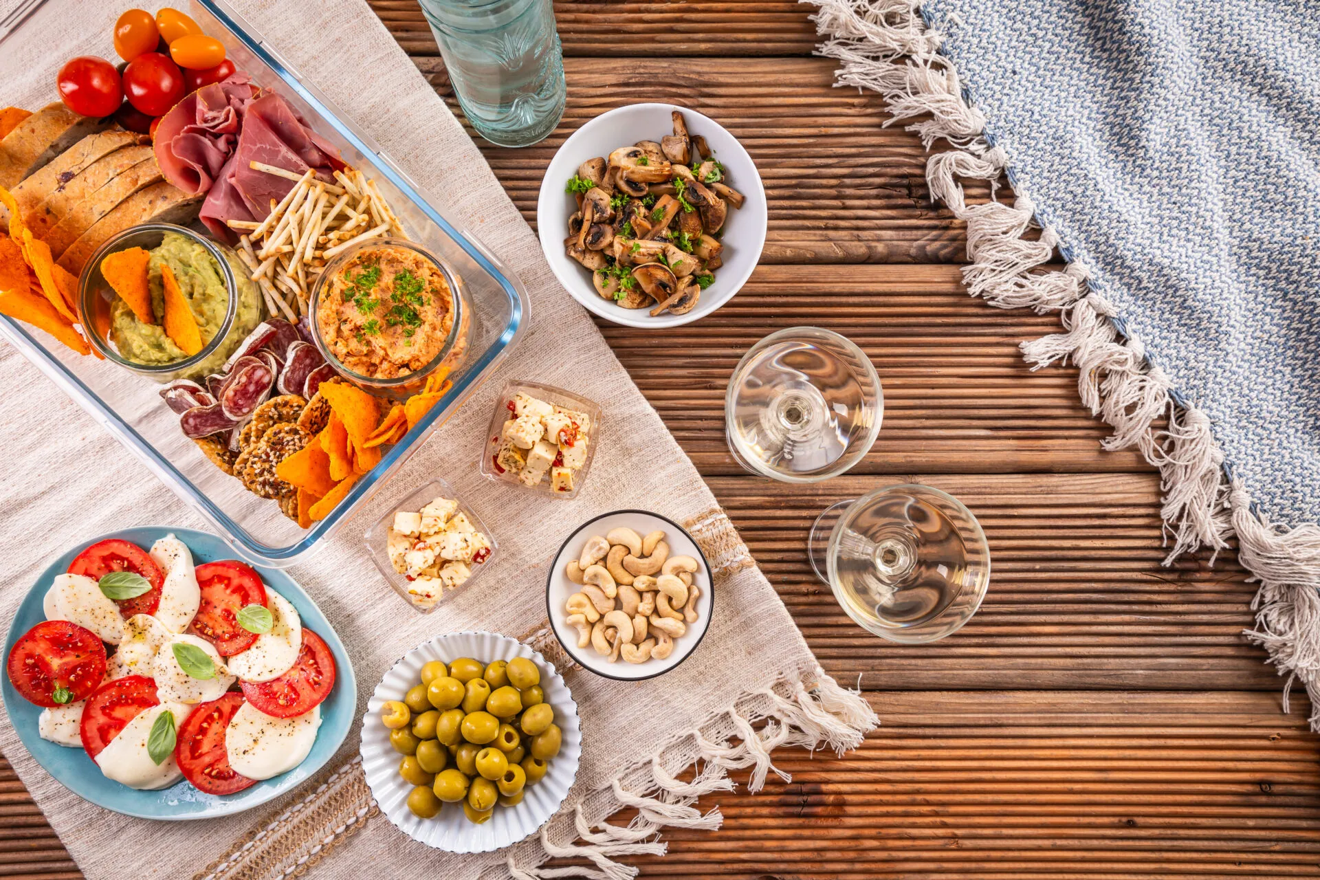 Aperitivo fit fatto in casa con stuzzichini leggeri, verdure, creme, crackers, formaggi, frutta secca e affettati.