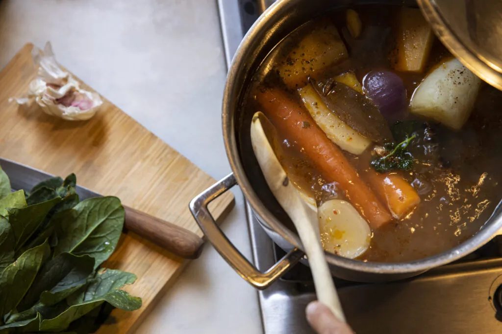 Cottura lenta del brodo con verdure fresche per fare il brodo perfetto ricco di sapore e leggero