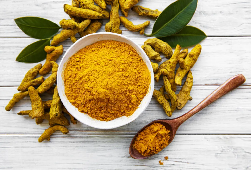 Curcuma in polvere e radice fresca, spezia dorata ideale per dare colore e sapore a ricette fit con verdure, riso e piatti sani