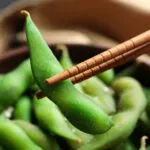 Edamame verdi nel baccello serviti con bacchette, i giovani fagioli di soia protagonisti della cucina fit