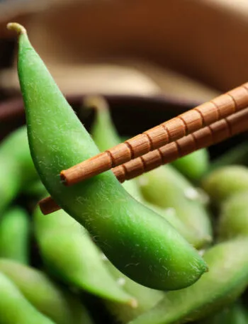Edamame verdi nel baccello serviti con bacchette, i giovani fagioli di soia protagonisti della cucina fit
