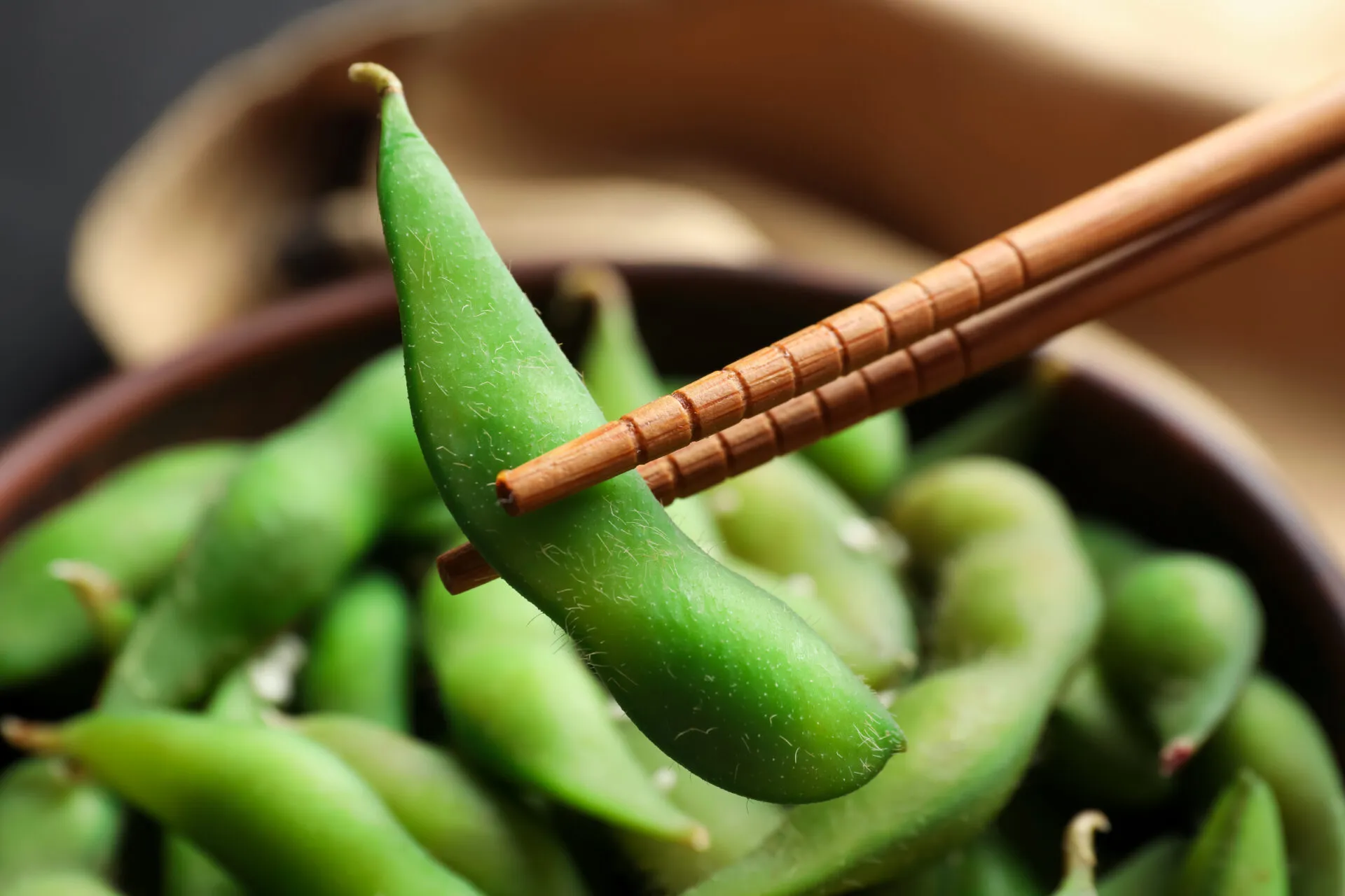 Edamame verdi nel baccello serviti con bacchette, i giovani fagioli di soia protagonisti della cucina fit