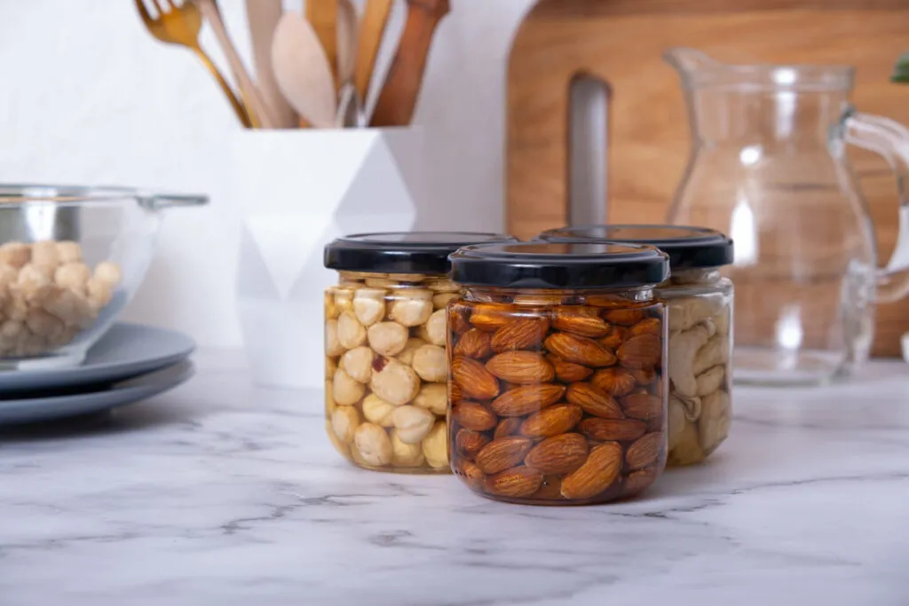 Barattoli di frutta secca con mandorle, nocciole e anacardi per una dispensa fit sana e organizzata