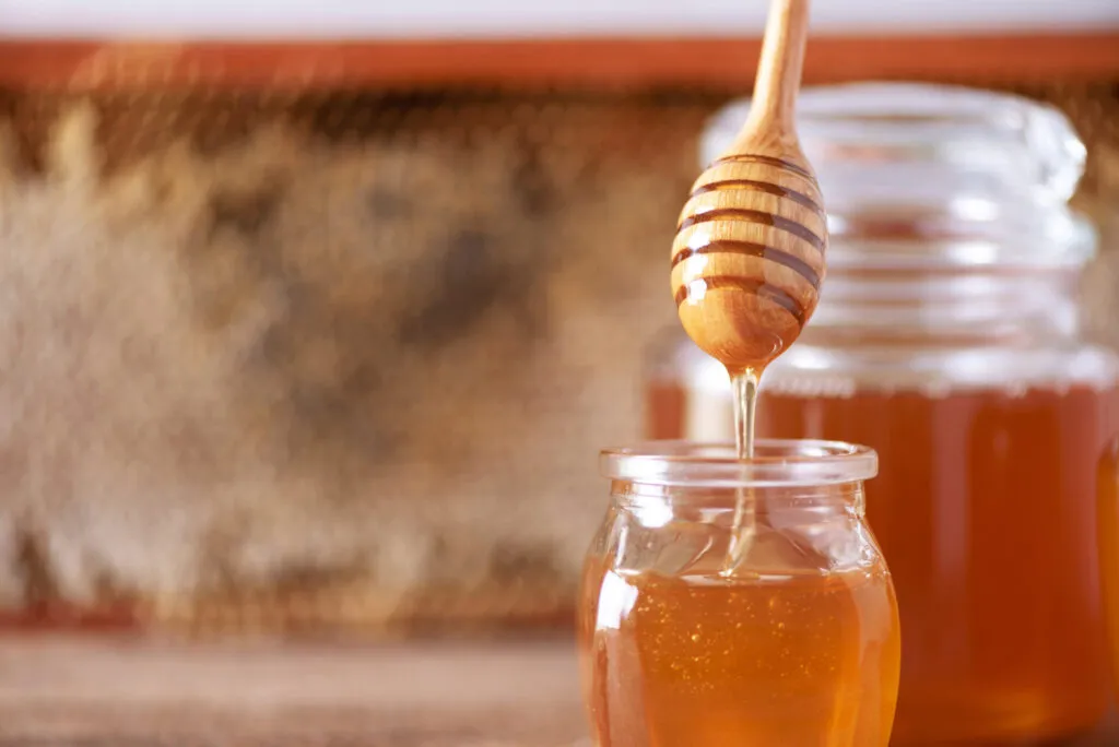 Barattolo di miele con cucchiaino, dolcificante naturale da tenere nella dispensa fit per ricette sane