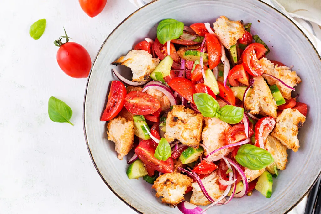 Panzanella con pane raffermo, pomodori freschi, cetrioli, cipolla rossa e basilico