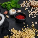 Ingredienti per ricette con legumi fit con ceci, spezie, basilico e aglio su piano da cucina