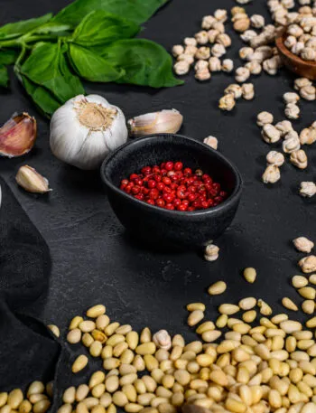 Ingredienti per ricette con legumi fit con ceci, spezie, basilico e aglio su piano da cucina