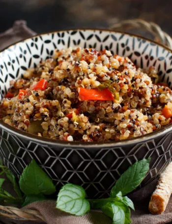 Bowl di quinoa con verdure colorate, menta fresca e grissini, ideale per ricette con quinoa fit.