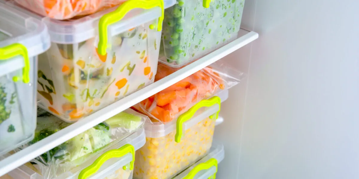 Contenitori e sacchetti con verdure e pasti pronti organizzati nel freezer