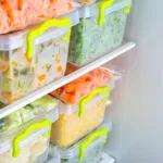 Contenitori e sacchetti con verdure e pasti pronti organizzati nel freezer